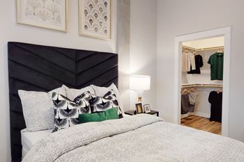 a bedroom with a bed and a closet with clothes in it